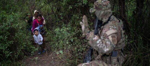 A member of the U.S. Border Patrol Tactical Unit (BORTAC) acknowledges family members after they illegally crossed the Rio Grande river into the United States from Mexico in Fronton, Texas, October 18, 2018 A member of the U.S. Border Patrol Tactical Unit (BORTAC) acknowledges family members after they illegally crossed the Rio Grande river into the United States from Mexico in Fronton, Texas, October 18, 2018 - Sputnik International