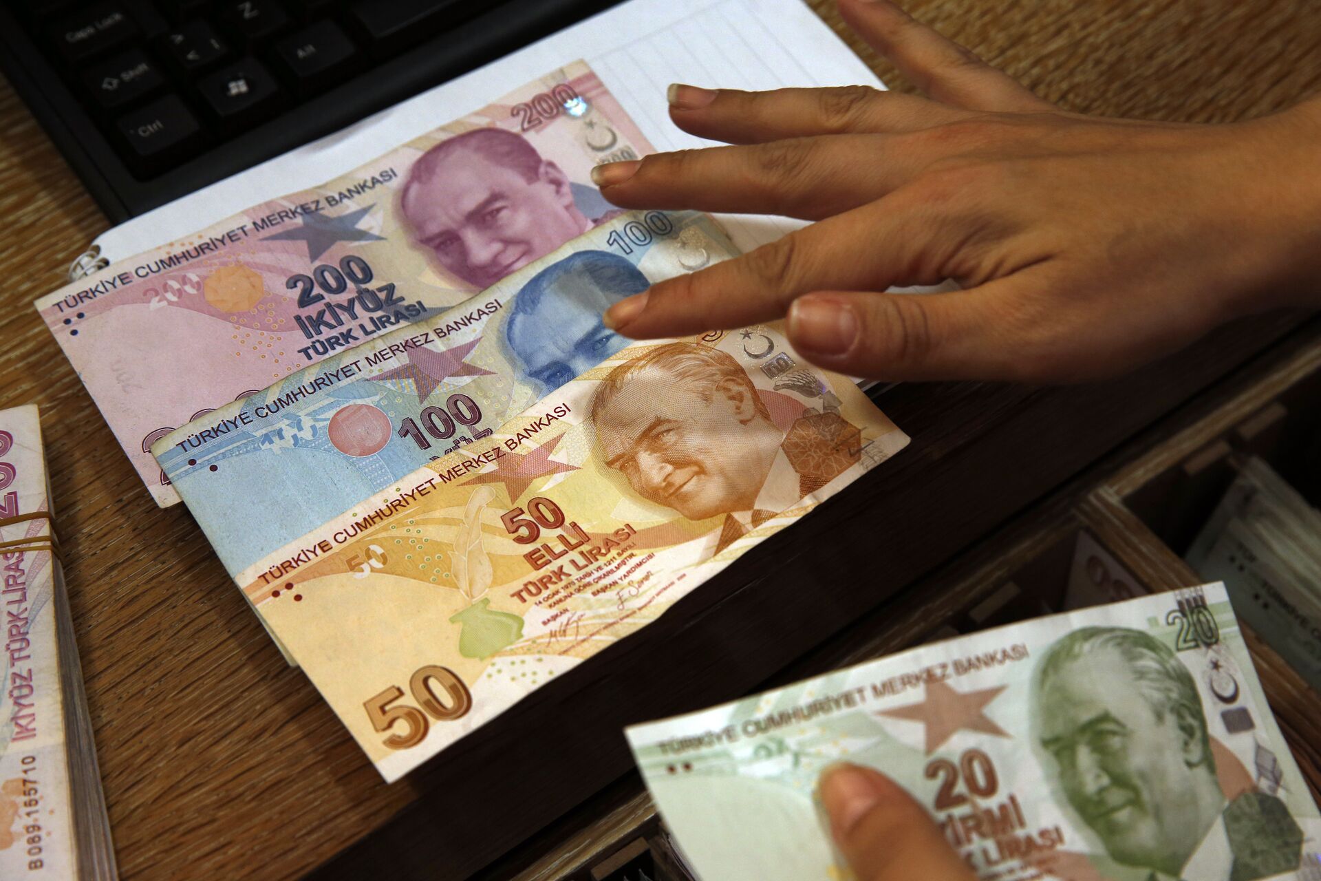 In this Wednesday, Aug. 15, 2018, file photo a worker at a currency exchange shop exhibits Turkish lira banknotes bearing pictures of modern Turkey's founder Mustafa Kemal Ataturk, in Istanbul.(file photo) - Sputnik International, 1920, 31.12.2021