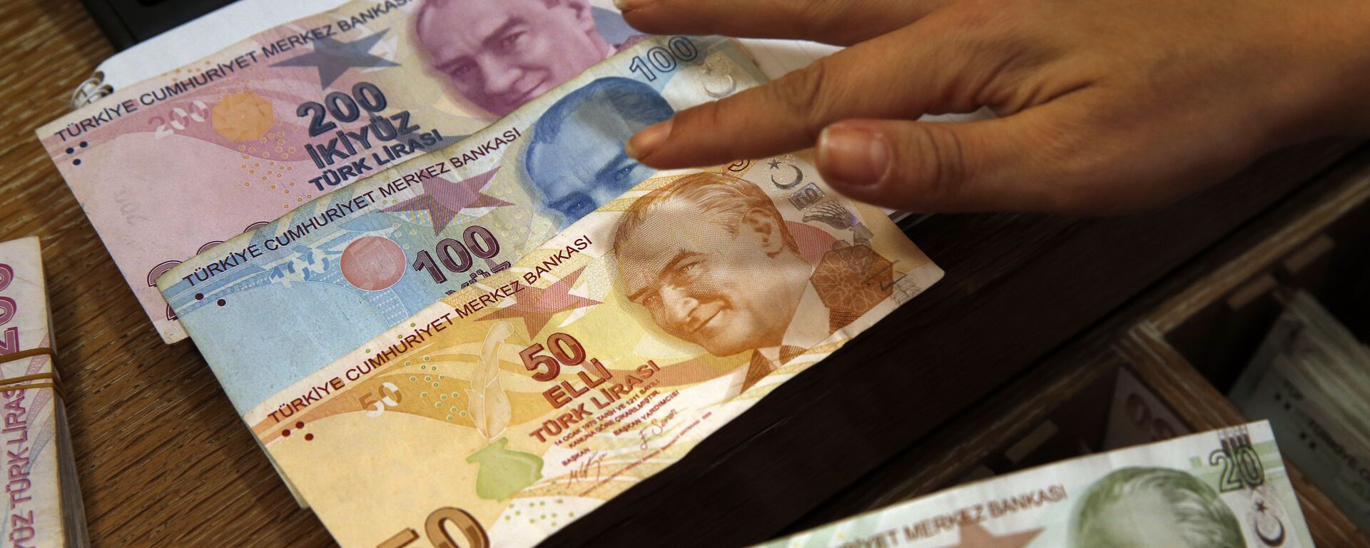 In this Wednesday, Aug. 15, 2018, file photo a worker at a currency exchange shop exhibits Turkish lira banknotes bearing pictures of modern Turkey's founder Mustafa Kemal Ataturk, in Istanbul.(file photo) - Sputnik International, 1920, 28.05.2023