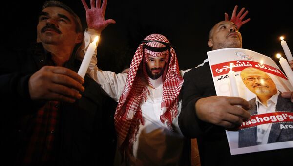 An activist, wearing a mask depicting Saudi Crown Prince Mohammed bin Salman, holds up his hands, painted with fake blood as he protests the killing of Saudi journalist Jamal Khashoggi, during a candlelight vigil outside Saudi Arabia's consulate in Istanbul, Thursday, Oct. 25, 2018 - Sputnik International