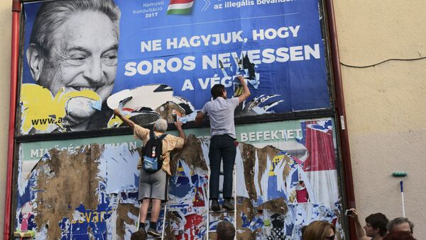 activists of the Egyutt (Together) party tear down an ad by the Hungarian government against George Soros, in Budapest, Hungary - Sputnik International