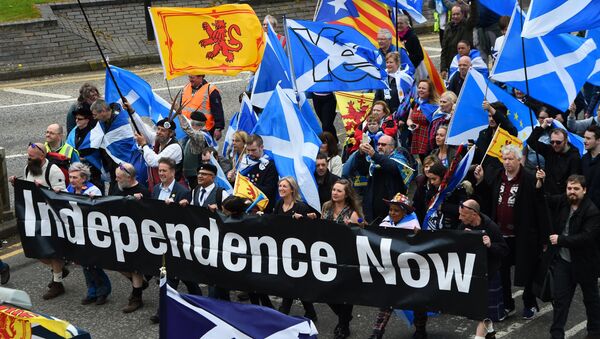 Thousands of demonstrators carry Saltire flags, the national flag of Scotland, as they march in support of Scottish independence through the streets of Glasgow, on May 5, 2018 - Sputnik International