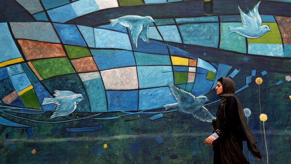 An Iranian woman walks past colourful walls in the capital Tehran on November 5, 2018 - Sputnik International