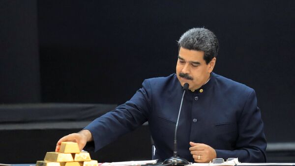 Venezuela's President Nicolas Maduro touches a gold bar as he speaks during a meeting with the ministers responsible for the economic sector at Miraflores Palace in Caracas, Venezuela March 22, 2018 - Sputnik International