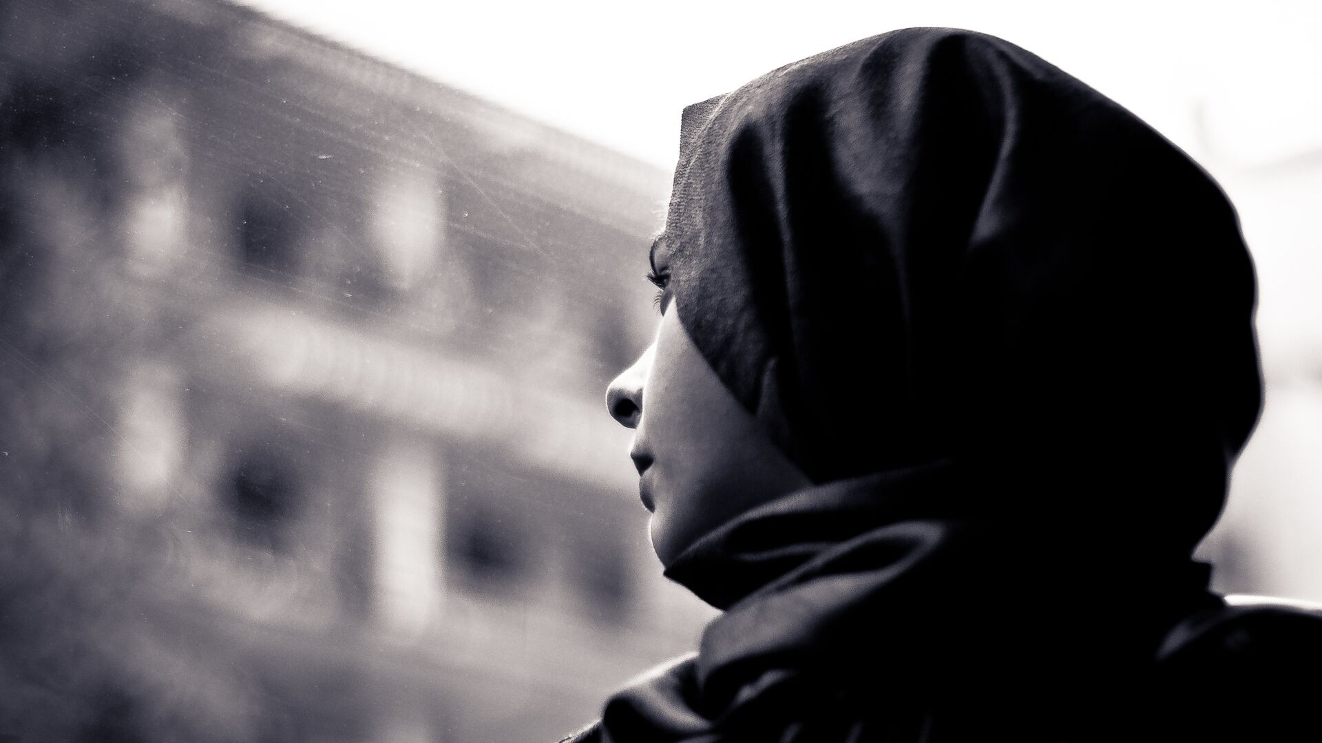 A woman wearing a hijab looks through the window - Sputnik International, 1920, 24.05.2021