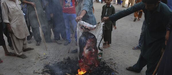 Pakistani protesters burn a poster image of Christian woman Asia Bibi, who has spent eight-years on death row accused of blasphemy and acquitted by a Supreme Court, in Hyderabad, Pakistan, Thursday, Nov. 1, 2018 - Sputnik International