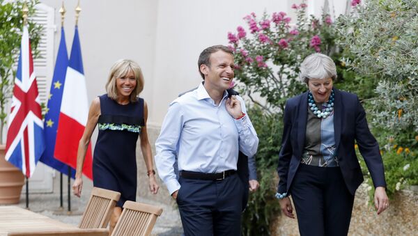 French President Emmanuel Macron and his wife Brigitte Macron, left, walk with British Prime Minister Theresa May, right, and her husband Philip May, hidden, prior to a diner at the Fort de Bregancon in Bornes-les-Mimosas, southern France, Friday Aug. 3, 2018 - Sputnik International