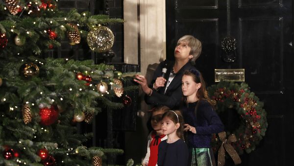 Britain's Prime Minister Theresa May stands with children as she switches on the Christmas tree lights at 10 Downing Street in London, Wednesday, Dec. 6, 2017. - Sputnik International