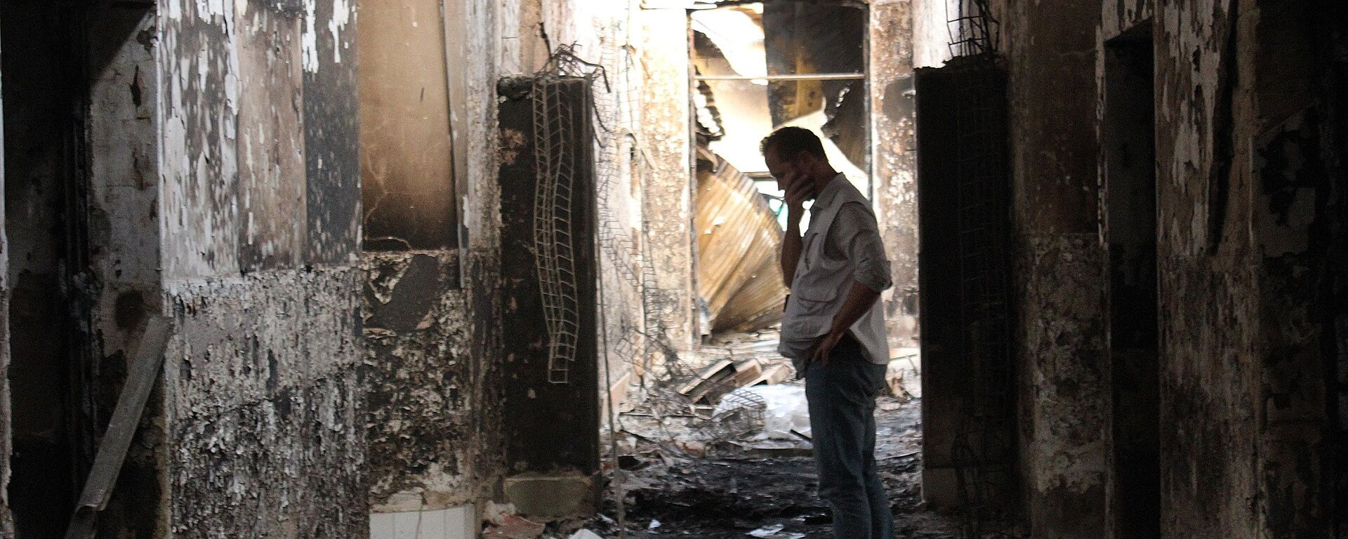 In this Friday, Oct. 16, 2015 photo, an employee of Doctors Without Borders walks inside the charred remains of their hospital after it was hit by a U.S. airstrike in Kunduz, Afghanistan - Sputnik International, 1920, 16.08.2021