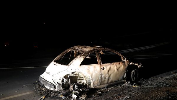 An abandoned vehicle is seen on a road during California Wildfire. - Sputnik International