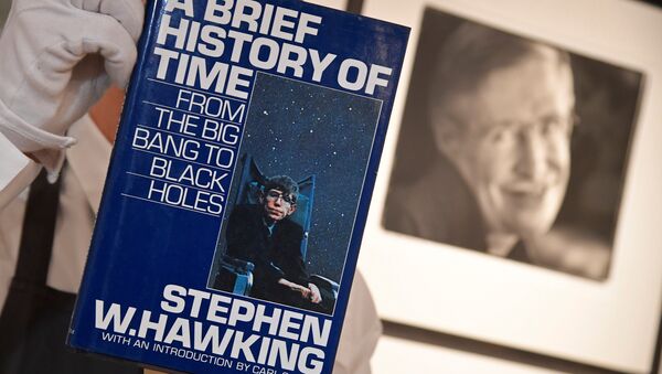 Fine-art handler Tom Richardson poses with a copy of A Brief History of Time which, has a thumb-print inside by author British theoretical physicist Stephen Hawking, ahead of an auction of items from Hawkinsg' personal estate at Christie's in London, Britain October 30, 2018. - Sputnik International