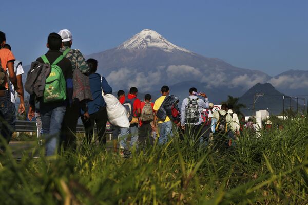 Central American migrants begin their morning trek as part of a thousands-strong caravan hoping to reach the U.S. border, as they face the Pico de Orizaba volcano upon departure from Cordoba, Veracruz state, Mexico, Monday, Nov. 5, 2018. A big group of Central Americans pushed on toward Mexico City from a coastal state Monday, planning to exit a part of the country that has long been treacherous for migrants seeking to get to the United States. - Sputnik International