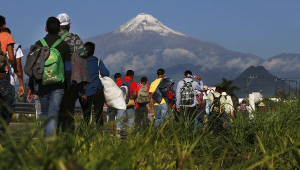 Central American migrants begin their morning trek as part of a thousands-strong caravan hoping to reach the U.S. border, as they face the Pico de Orizaba volcano upon departure from Cordoba, Veracruz state, Mexico, Monday, Nov. 5, 2018. A big group of Central Americans pushed on toward Mexico City from a coastal state Monday, planning to exit a part of the country that has long been treacherous for migrants seeking to get to the United States. - Sputnik International