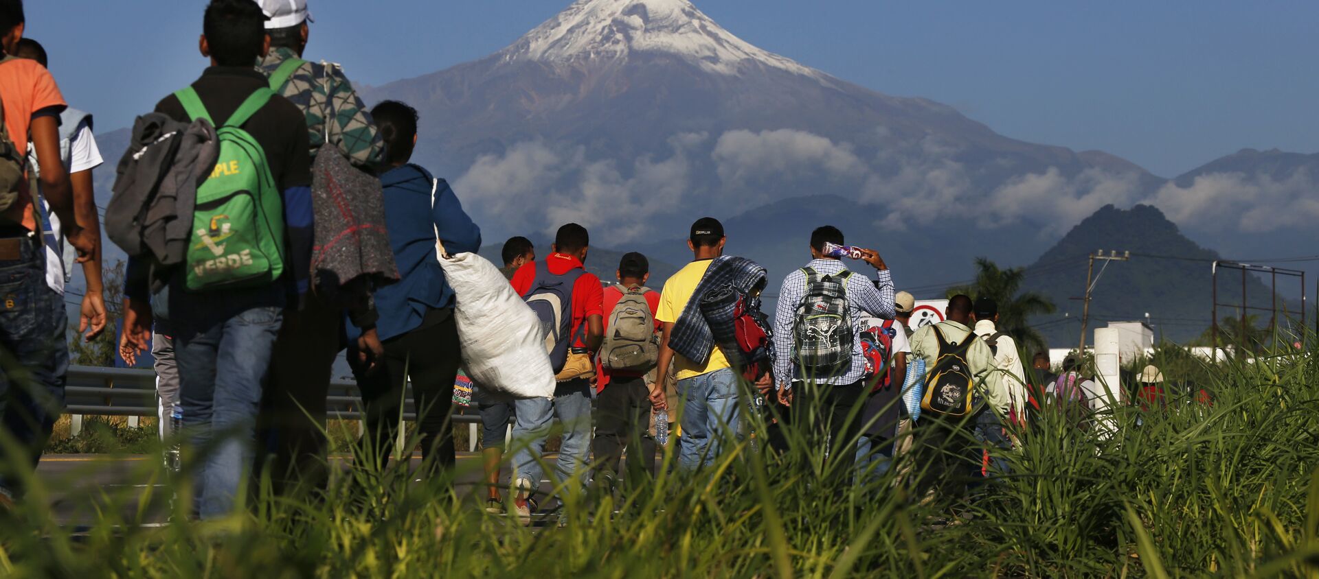 Central American migrants begin their morning trek as part of a thousands-strong caravan hoping to reach the U.S. border, as they face the Pico de Orizaba volcano upon departure from Cordoba, Veracruz state, Mexico, Monday, Nov. 5, 2018. A big group of Central Americans pushed on toward Mexico City from a coastal state Monday, planning to exit a part of the country that has long been treacherous for migrants seeking to get to the United States. - Sputnik International, 1920, 24.02.2021
