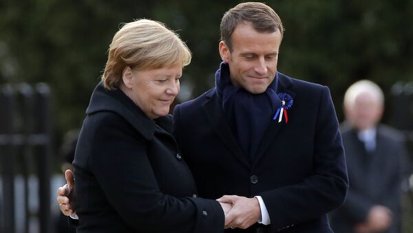 French President Emmanuel Macron, right, holds the hands of German Chancellor Angela Merkel during a ceremony in Compiegne, north of Paris, Saturday, Nov. 10, 2018.  - Sputnik International