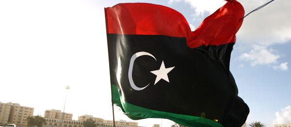 A Libyan man waves a national flag - Sputnik International