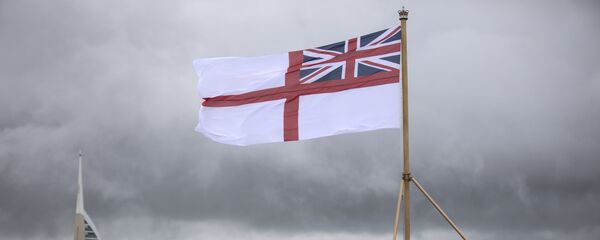 A naval officer looks up at the white ensign flying at the stern of the aircraft carrier HMS Queen Elizabeth, which has been beset with technical problems A naval officer looks up at the white ensign flying at the stern of the aircraft carrier HMS Queen Elizabeth, which has been beset with technical problems - Sputnik International