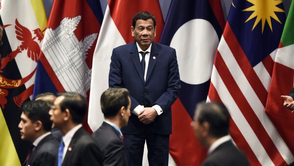 Philippine President Rodrigo Duterte waits on stage to pose with other leaders for a group photo before the start of the ASEAN-Plus Three (APT) summit on the sidelines of the 33rd Association of Southeast Asian Nations (ASEAN) summit in Singapore on November 15, 2018 - Sputnik International