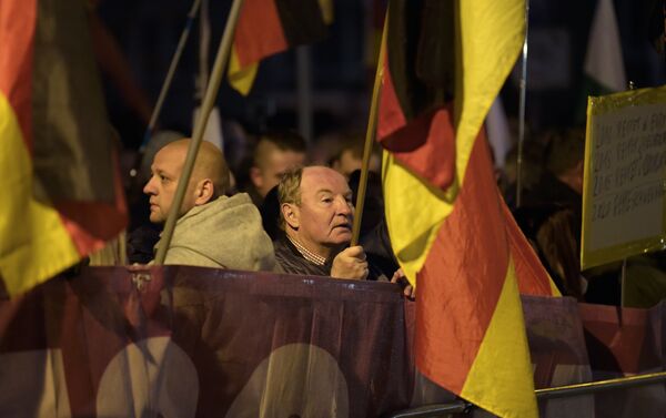 Demonstrators with German flags attend a protest against the visit of German Chancellor Angela Merkel at the East German city Chemnitz on Friday, Nov. 16, 2018. - Sputnik International