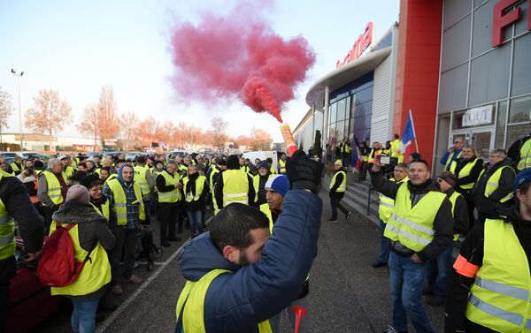A demonstrators holds a flare during a demonstration of Yellow Vests (Gilets jaunes) against the rising of the fuel and oil prices on November 17, 2018 in Vendenheim, eastern France. - Sputnik International