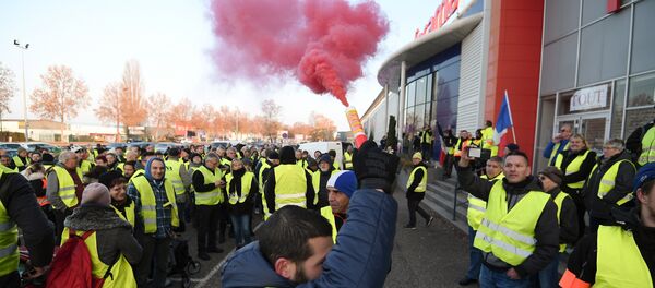 A demonstrators holds a flare during a demonstration of Yellow Vests (Gilets jaunes) against the rising of the fuel and oil prices on November 17, 2018 in Vendenheim, eastern France. - Sputnik International
