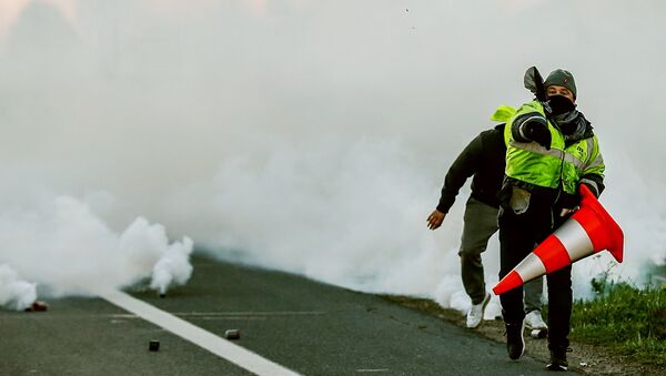A man throws a projectile on Caen's circular road on November 18, 2018 in Caen, northwestern France, on a second day of action after a nationwide popular initiated day of protest called yellow vest (Gilets Jaunes in French) movement against high fuel prices which has mushroomed into a widespread protest against stagnant spending power under French President. - Sputnik International
