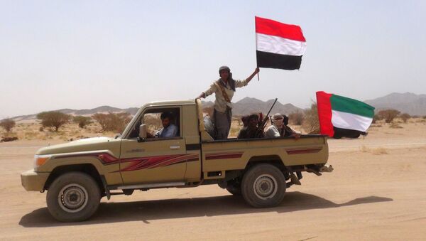 Yemeni tribesmen from the Popular Resistance Committees, supporting forces loyal to Yemen's Saudi-backed fugitive President Abedrabbo Mansour Hadi, hold the Emirati (R) and Yemeni flag as they drive in Marib province, east of the Yemeni capital, Sanaa, on September 20, 2015 - Sputnik International