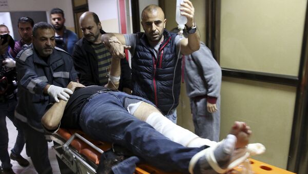 AP photographer Rashed Rashid rushed into the hospital by his colleagues after he was shot in the leg by an Israeli military sniper while filming a protest in Gaza. - Sputnik International