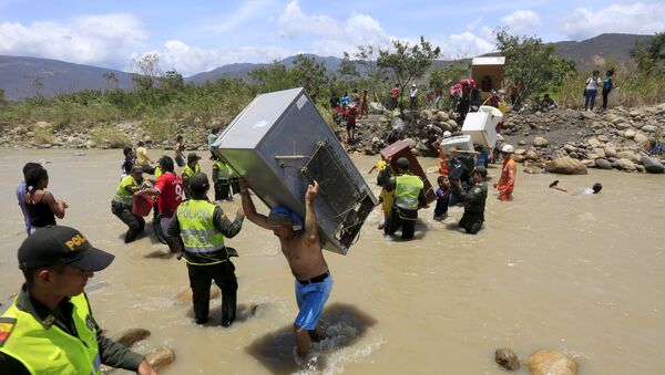 A man carries a refrigerator while crossing the Tachira river border with Venezuela into Colombia, near Villa del Rosario village August 25, 2015 - Sputnik International