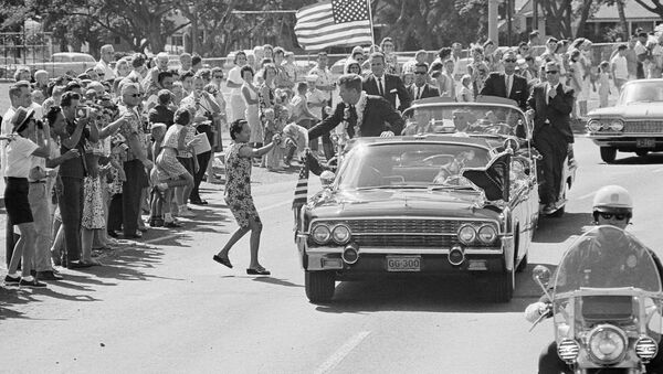 A woman runs into the street and tosses President John Kennedy a floral lei, which he caught,during a motorcade through Honolulu June 9, 1963 from the Pearl Harbor Naval Base to a Waikiki Beach Hotel where he made a strong plea for civil rights before a conference of the nation's mayors - Sputnik International