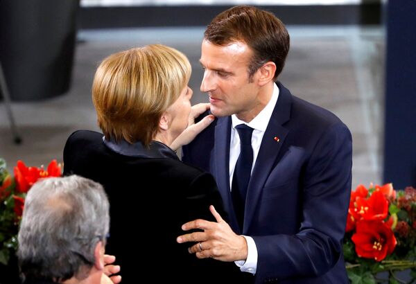French President Emmanuel Macron hugs German Chancellor Angela Merkel after giving a speech during a ceremony at the Bundestag - Sputnik International
