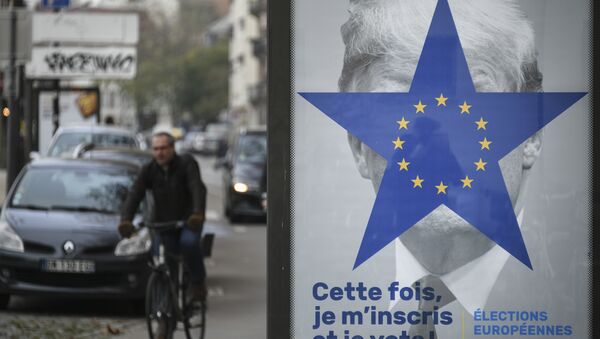 A cyclist rides near a street poster depicting the twelve-star circle from the European Union flag within a blue five-pointed star covering the face of what is deemed to be a portrait of US President Donald Trump, and a text reading in This time, I register and I vote, on November 21, 2018, in Strasbourg, eastern France, ahead of European Elections in May 2019. - Sputnik International
