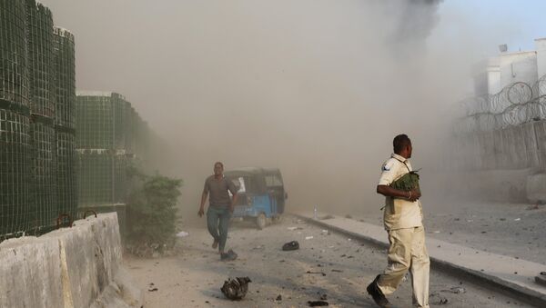 Somali security officers run from the scene of an explosion in Mogadishu - Sputnik International