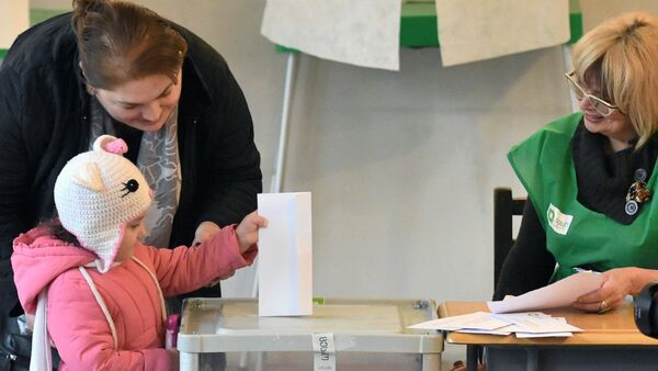 A girl puts the ballot in the ballot box at one of the polling stations in Tbilisi. - Sputnik International