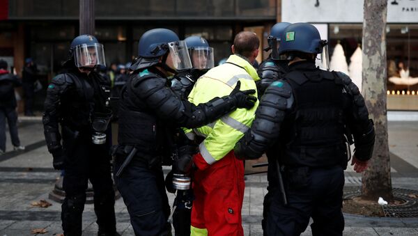 French riot police apprehend a protester wearing a yellow vest, a symbol of a French drivers' protest against higher fuel prices, during clashes on the Champs-Elysees in Paris, France, November 24, 2018. Picture taken November 24, 2018 - Sputnik International