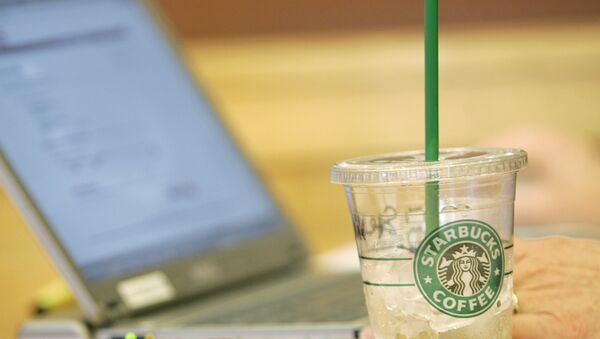 An iced drink sits next to a laptop computer in use Monday, Feb. 11, 2008, at a Starbucks Corp. store near the University of Washington in Seattle. Starbucks and AT&T Inc. will start offering a mix of free and paid wireless Internet service in most of the international coffee retailer's U.S. shops, beginning this spring. - Sputnik International