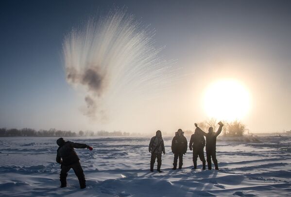 A villager throws hot water into the air while harvesting ice in Siberia - Sputnik International