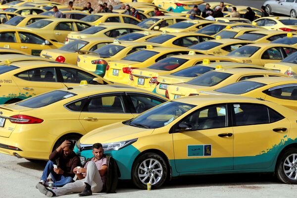 Taxi drivers sit next to their taxis during a protest, outside the Parliament in Amman, Jordan - Sputnik International