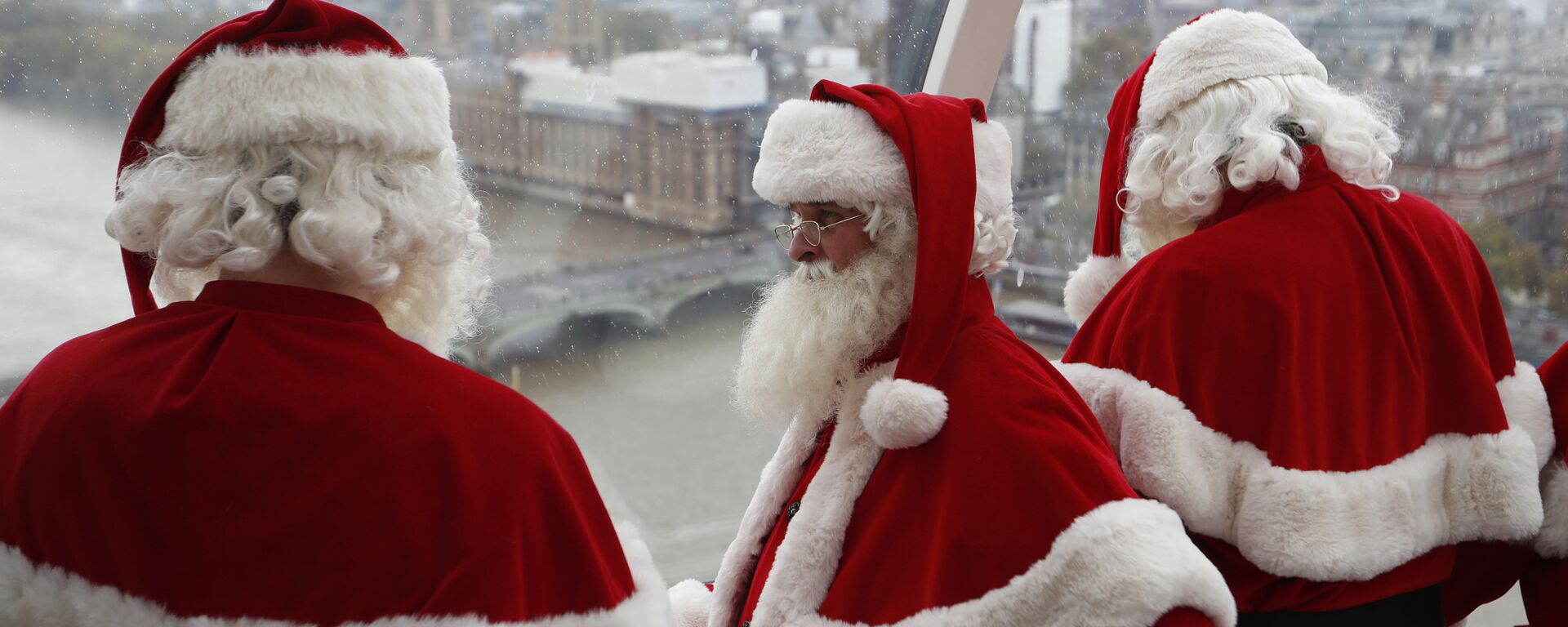 Santas from the Santa School take a look at the London skyline from a pod in the London Eye in London, Tuesday, Nov. 6, 2018. These Santas will be working in shops and malls around London as the Christmas season approaches. - Sputnik International, 1920, 15.12.2022