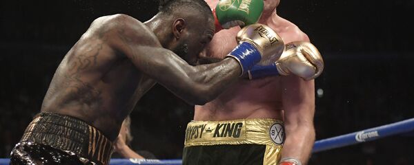 Deontay Wilder, left, connects with Tyson Fury, of England, during a WBC heavyweight championship boxing match Saturday, Dec. 1, 2018, in Los Angeles Deontay Wilder, left, connects with Tyson Fury, of England, during a WBC heavyweight championship boxing match Saturday, Dec. 1, 2018, in Los Angeles - Sputnik International