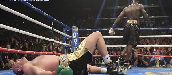 Tyson Fury lies prostrate on the canvas in the final round of Saturday's fight with Deontay Wilder in Los Angeles - Sputnik International