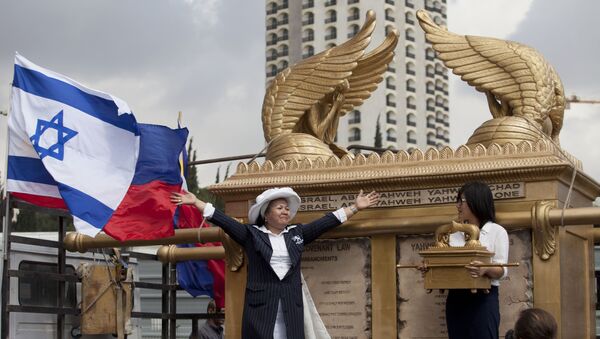 Grace Galindez-Gupana, left, a businesswoman from the Philippines, stands next to what she says is the world's largest model of the Ark of the Covenant, the biblical chest which was said to have held the Ten Commandments in Jerusalem, Tuesday, Sept. 24, 2013. - Sputnik International