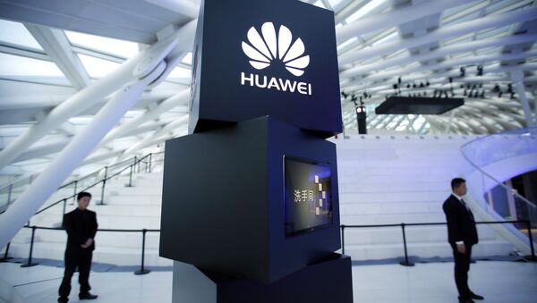 Security personnel stand near a pillar with the Huawei logo - Sputnik International