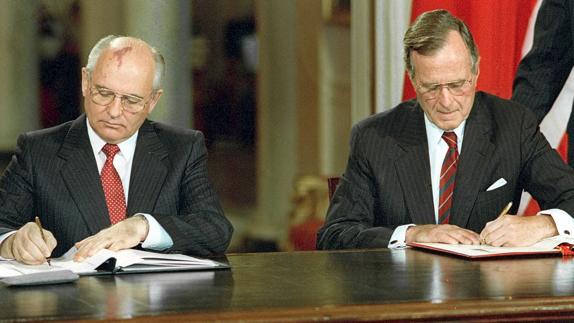 Soviet President Mikhail Gorbachev, left, and U.S. President George Bush signing bilateral documents during Gorbachev's official visit to the United States - Sputnik International, 1920, 30.05.2021
