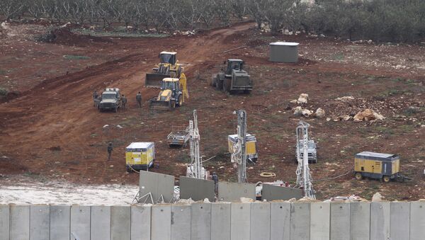 An Israeli military digger works on the Lebanese-Israeli border next to a wall that was built by Israel in the southern village of Kafr Kila, Lebanon, Tuesday, Dec. 4, 2018. - Sputnik International