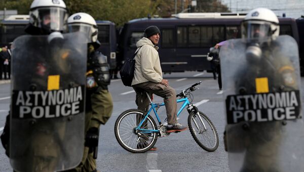 A man on a bike stands behind a police cordon guarding an anniversary rally marking the 2008 police shooting of 15-year-old student, Alexandros Grigoropoulos, in Athens - Sputnik International