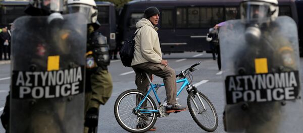 A man on a bike stands behind a police cordon guarding an anniversary rally marking the 2008 police shooting of 15-year-old student, Alexandros Grigoropoulos, in Athens - Sputnik International