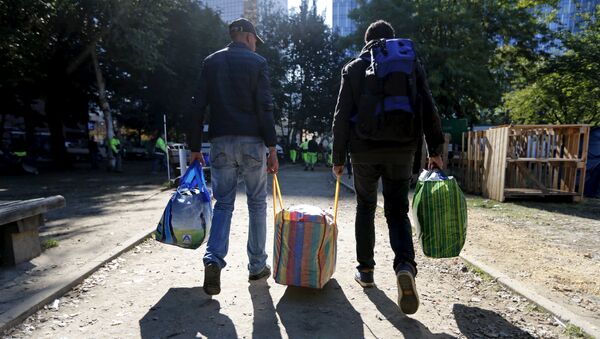 Migrants carry their belongings as they leave a makeshift camp for refugees outside the foreign office in Brussels, Belgium October 2, 2015 - Sputnik International