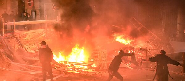 Protestors throw projectiles in a burning barricade during a demonstration of yellow vests (gilets jaunes) against rising costs of living they blame on high taxes in Toulouse, southern France, on December 8, 2018 - Sputnik International