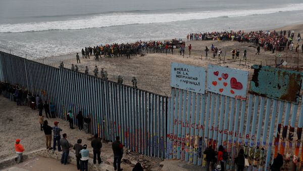 People take part in a gathering in support of the migrant caravan in San Diego, U.S., close to the border wall between the United States and Mexico, as seen from Tijuana, Mexico December 10, 2018 - Sputnik International